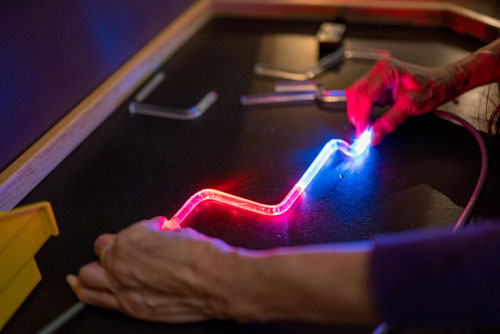 Hands holding a multi color lit tube