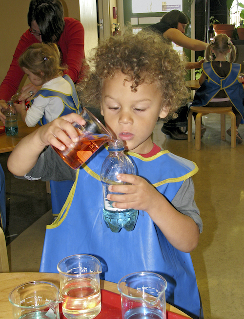 Child mixing colored liquids