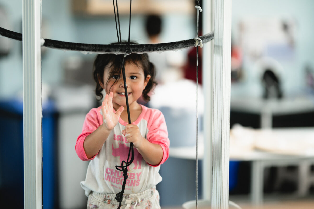 Child waves at the bubble exhibit