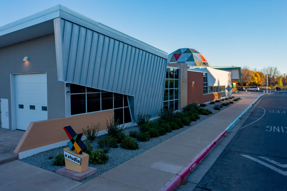 Exterior of X Studio Building with the view of the trades yard garage doors and the length of the building leading up to the Tiguex Park